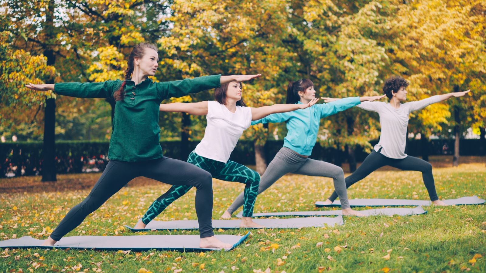 Groupe en séance de Pilates sur des tapis, dans un parc